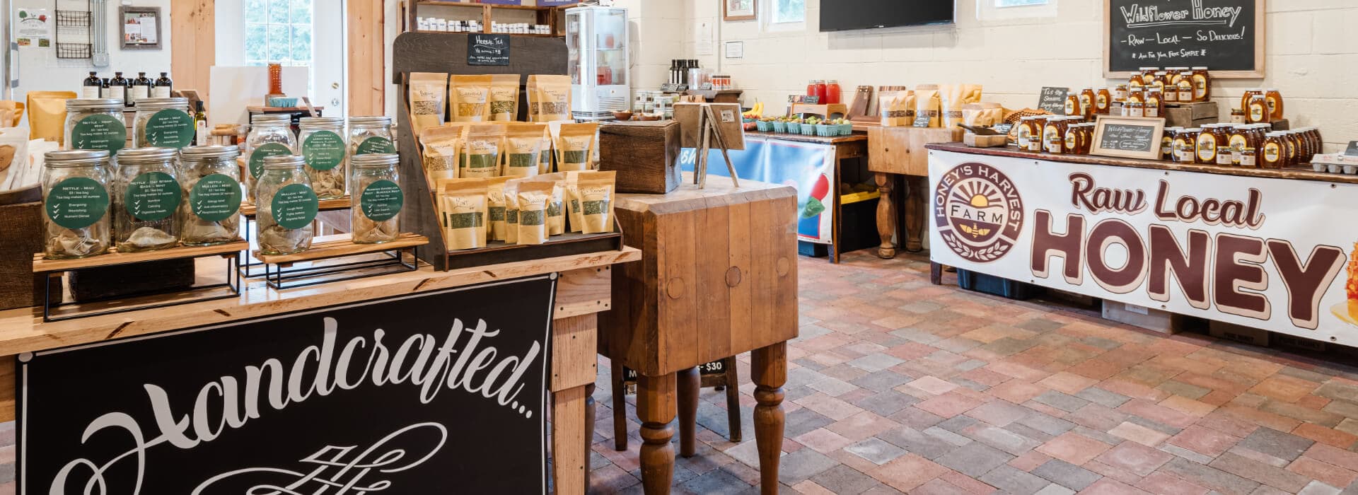 A quaint shop interior displaying jars of handcrafted goods and a prominent sign for raw local honey.
